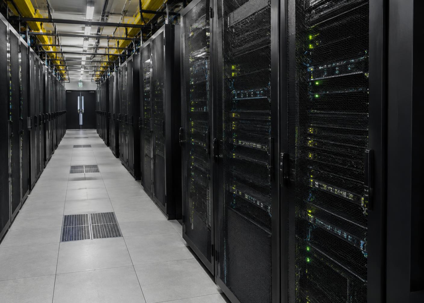 Illustrative photo of a corridor of server racks with green status lights in a data centre